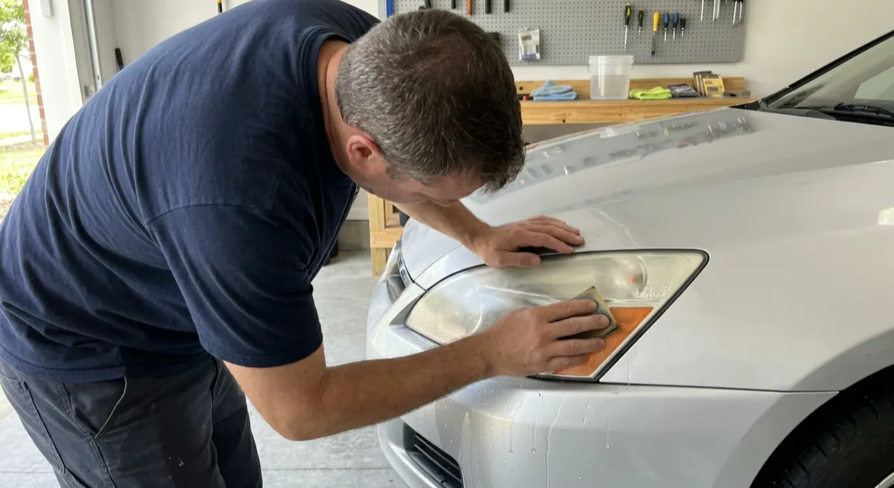 Wet-Sanding Headlights: Grit Progression & Technique — a car headlight shown half foggy and yellowed, half crystal clear